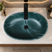 600x380x200 mm deep green artificial stone table top wash basin with matte finish, white marble-style veining and sculpted oval design for modern luxury bathrooms.