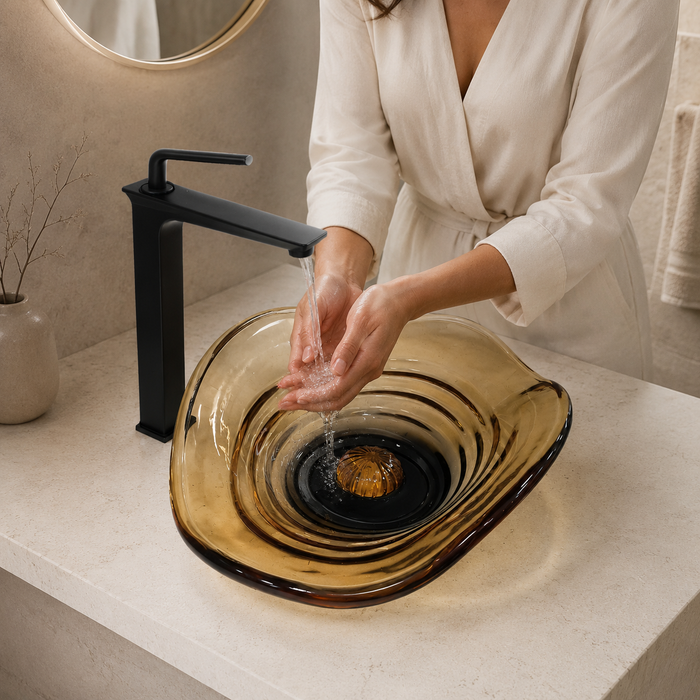 Amber sculptural glass table top wash basin with layered contours, smoky-Orange centre and matching glass waste coupling.