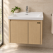 Bassino 600 mm wall-mounted bathroom vanity with glossy white ceramic basin, natural oak PVC cabinet, stainless-steel support and two-door storage.
