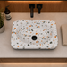 Bassino terrazzo design table top wash basin 460x320x140 mm with glossy white multicolor stone pattern and grey base for modern bathroom countertop.