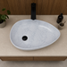 Bassino white marble pattern table top wash basin 560 × 355 × 130 mm with asymmetrical oval design for modern luxury bathroom countertops.