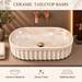 Beige marble ceramic table top wash basin with glossy finish, fluted exterior and elongated oval design, 550 × 350 × 150 mm.