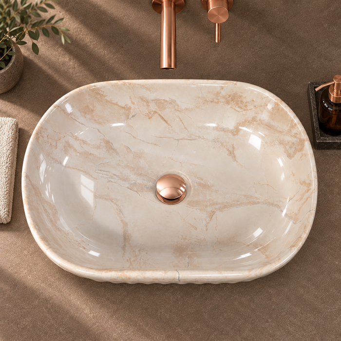 Beige marble ceramic table top wash basin with glossy finish, fluted exterior and elongated oval design, 550 × 350 × 150 mm.