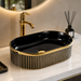 Black and gold luxury table top wash basin with glossy interior, vertical gold detailing and 490 × 320 × 150 mm size for modern bathroom countertops.