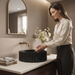 Black artificial stone table top wash basin with matte speckled finish, round shape and vertical fluted exterior, 390 × 390 × 150 mm.