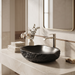 Black artificial stone table top wash basin with organic free-form shape, rough rock-textured exterior and 490 × 370 × 140 mm size.