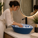 Blue and white floral ceramic table top wash basin with glossy finish, oval designer countertop basin measuring 555 × 355 × 170 mm for modern bathrooms.