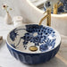 Blue and white floral round ceramic table top wash basin 375x375x125 mm with matte finish and sculpted fluted exterior design.