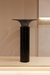 Black marble pedestal against a beige wall
