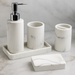 Marble-textured bathroom accessory set including a dispenser, two cups, and a soap dish on a neutral background.