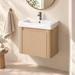 Compact light-wood wall-mounted bathroom vanity with integrated white basin and single-door storage