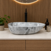Designer grey and white marble pattern table top wash basin 560 × 355 × 130 mm with glossy finish and asymmetrical oval shape for modern luxury bathrooms.