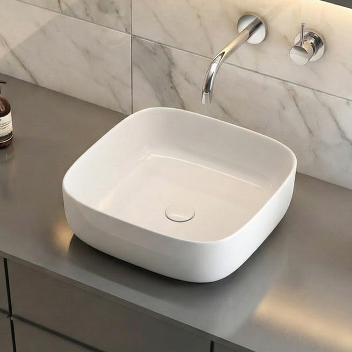 Bathroom vanity with white sink, gray countertop, and marble walls.