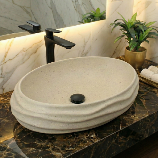 Bathroom vanity with a stone sink and black faucet, featuring a marble wall and decorative elements.