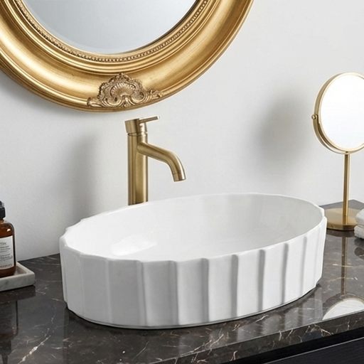White ceramic sink with gold faucet and mirror in a bathroom setting