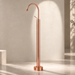Glossy Rose gold floor mount basin faucet with tall curved spout and single lever handle, modern freestanding bathroom tap for luxury wash basin installations by Bassino.