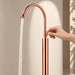 Glossy Rose gold floor mount basin faucet with tall curved spout and single lever handle, modern freestanding bathroom tap for luxury wash basin installations by Bassino.