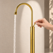 Glossy gold floor mount basin faucet with tall curved spout and single lever handle, modern freestanding bathroom tap for luxury wash basin installations by Bassino.