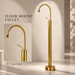 Glossy gold floor mount basin faucet with tall curved spout and single lever handle, modern freestanding bathroom tap for luxury wash basin installations by Bassino.