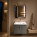 Grey wall-mounted vanity set with upper mirror cabinet and lower storage cabinet doors open, showing spacious internal storage.