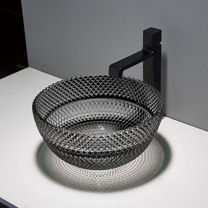 Black textured sink with black faucet on a white countertop against a gray wall.
