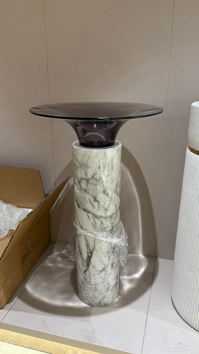 Small round table with a marble-like base on a neutral background