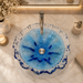 Luxury blue crystal glass table top wash basin with sculpted wavy edges, 420 × 420 × 130 mm, displayed in a modern bathroom.