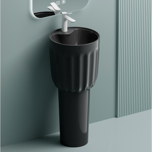 Black freestanding sink with white faucet against a light gray wall.