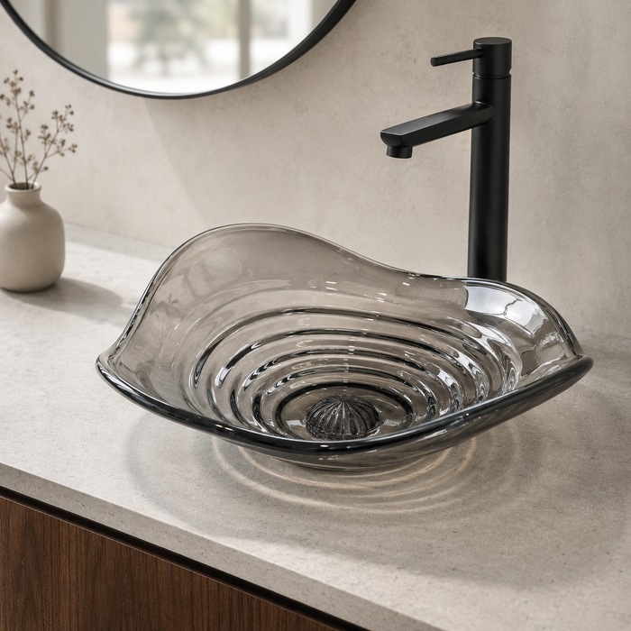 Smoky transparent glass table top wash basin with sculpted concentric design, matching glass waste coupling ball and 450 × 320 × 130 mm dimensions.