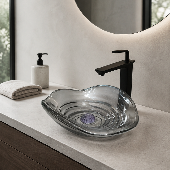 Smoky transparent glass table top wash basin with sculpted concentric design, matching glass waste coupling ball and 450 × 320 × 130 mm dimensions.