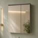 Wall-mounted bronze-grey bathroom vanity set with wave-textured cabinet doors, white basin, mirrored storage cabinet, and integrated LED lighting.