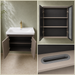 Wall-mounted bronze-grey bathroom vanity set with wave-textured cabinet doors, white basin, mirrored storage cabinet, and integrated LED lighting.