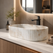 White and beige marble-finish table top wash basin with fluted exterior design, rounded rectangular shape and 510 × 310 × 120 mm size.