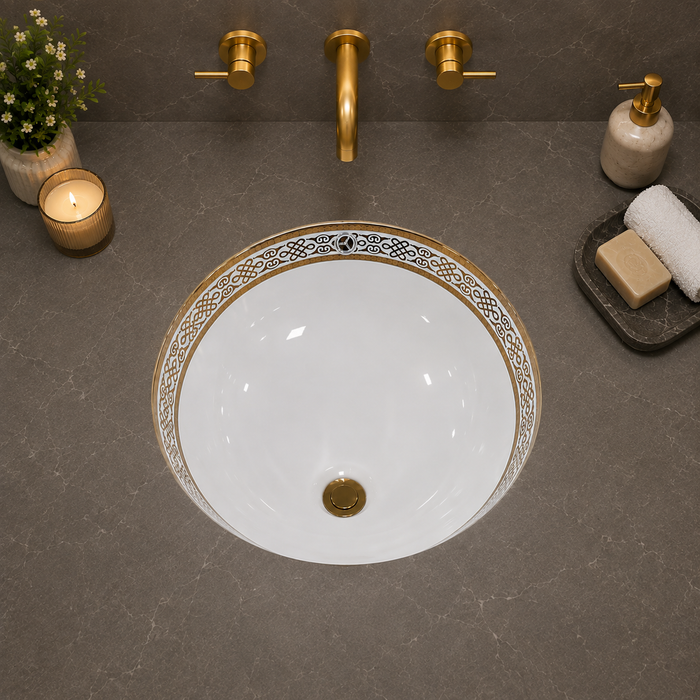 White and gold designer ceramic under counter wash basin with glossy finish, 490 × 400 × 200 mm oval undermount bathroom basin with decorative gold border pattern.