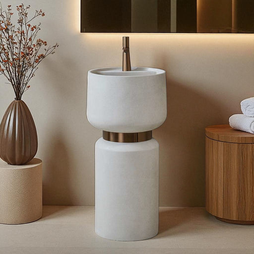 White freestanding sink with bronze accents in a bathroom setting